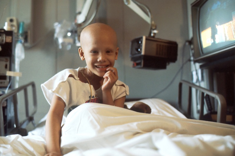 Young cancer patient smiling in a hospital bed